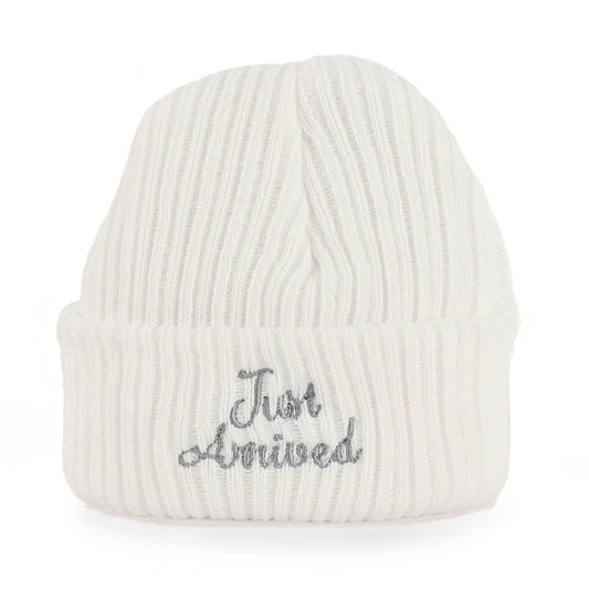 White knit baby beanie with 'Just Arrived' embroidery on a white background