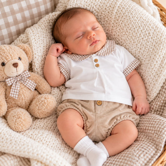 newborn boy in beige shorts with white shirt with beige collar by calamaro