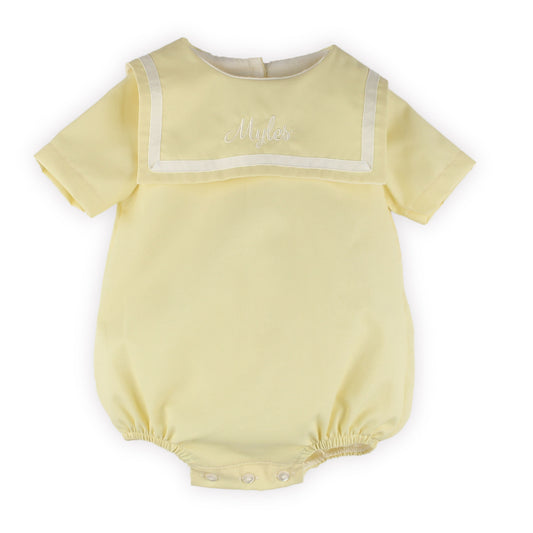 Personalised ellow baby romper with white trim on a white background