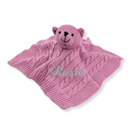 Personalised pink knitted baby comforter with teddy head and embroidered name on cable knit blanket
