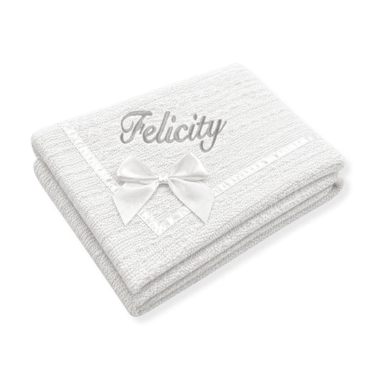 White personalised baby blanket with knitted texture, satin ribbon trim and bow