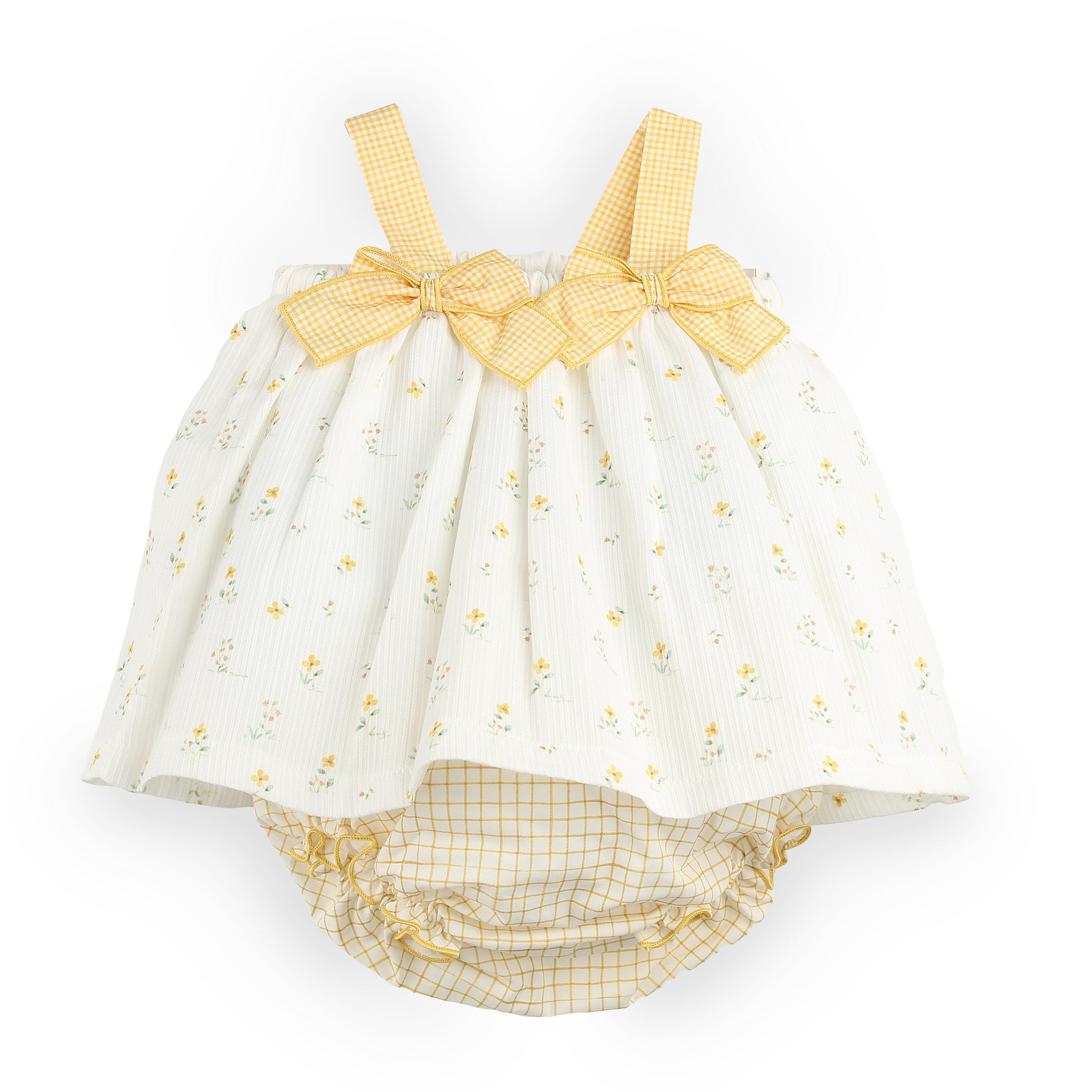A baby romper in white muslin fabric with a small yellow floral print, featuring yellow gingham checkered straps and bows, and a matching yellow gingham diaper cover underneath.