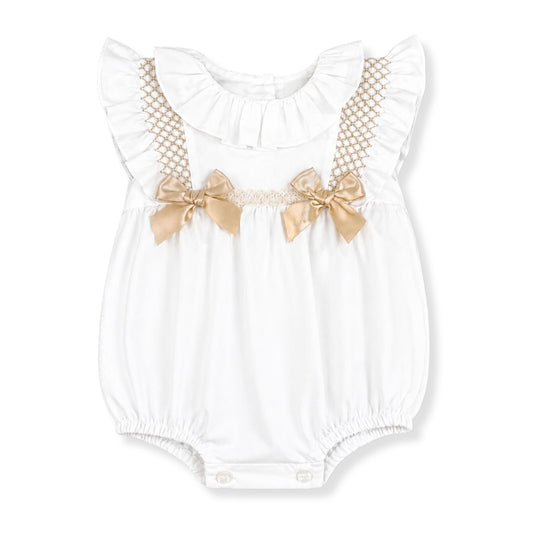 White baby romper with gold bow details on a white background