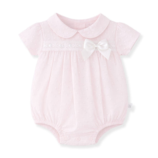 Pink baby romper with a white collar and bow on a white background