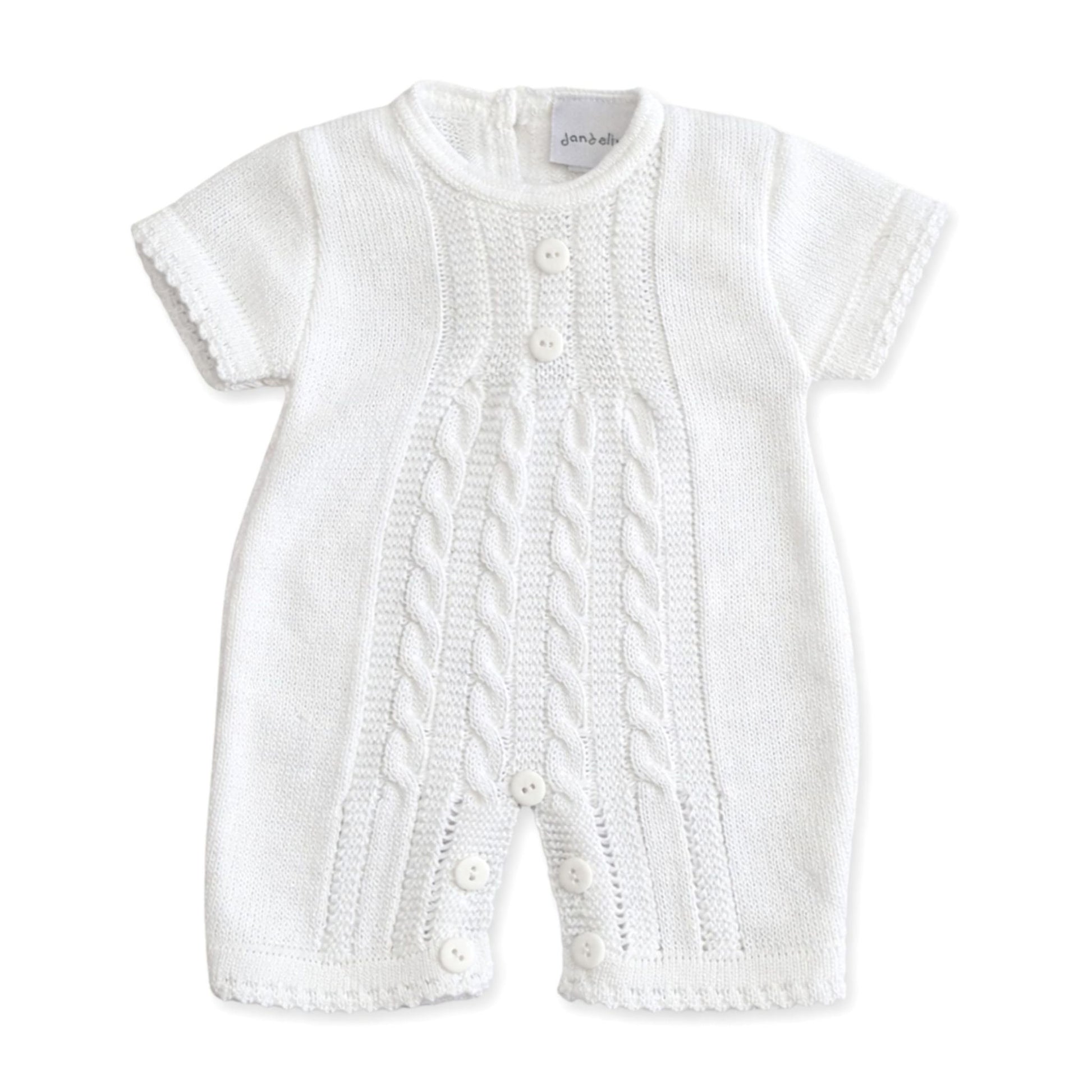 White knitted baby romper with cable pattern on a white background