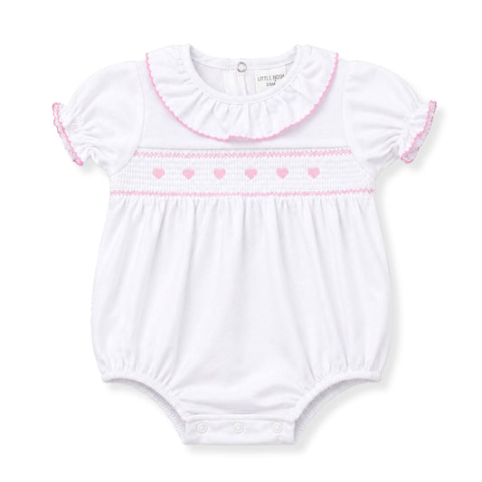 White baby romper with pink trim on a white background