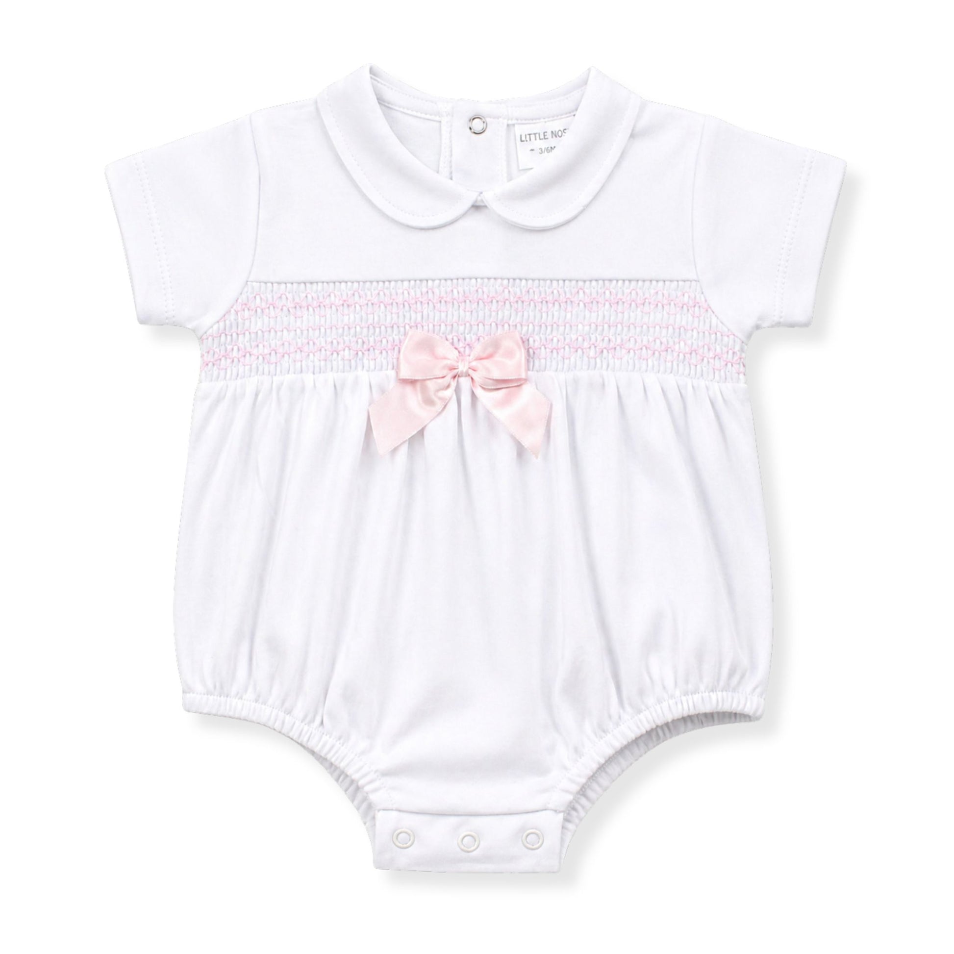 White baby romper with pink bow on a white background