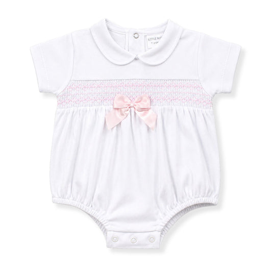White baby romper with pink bow on a white background