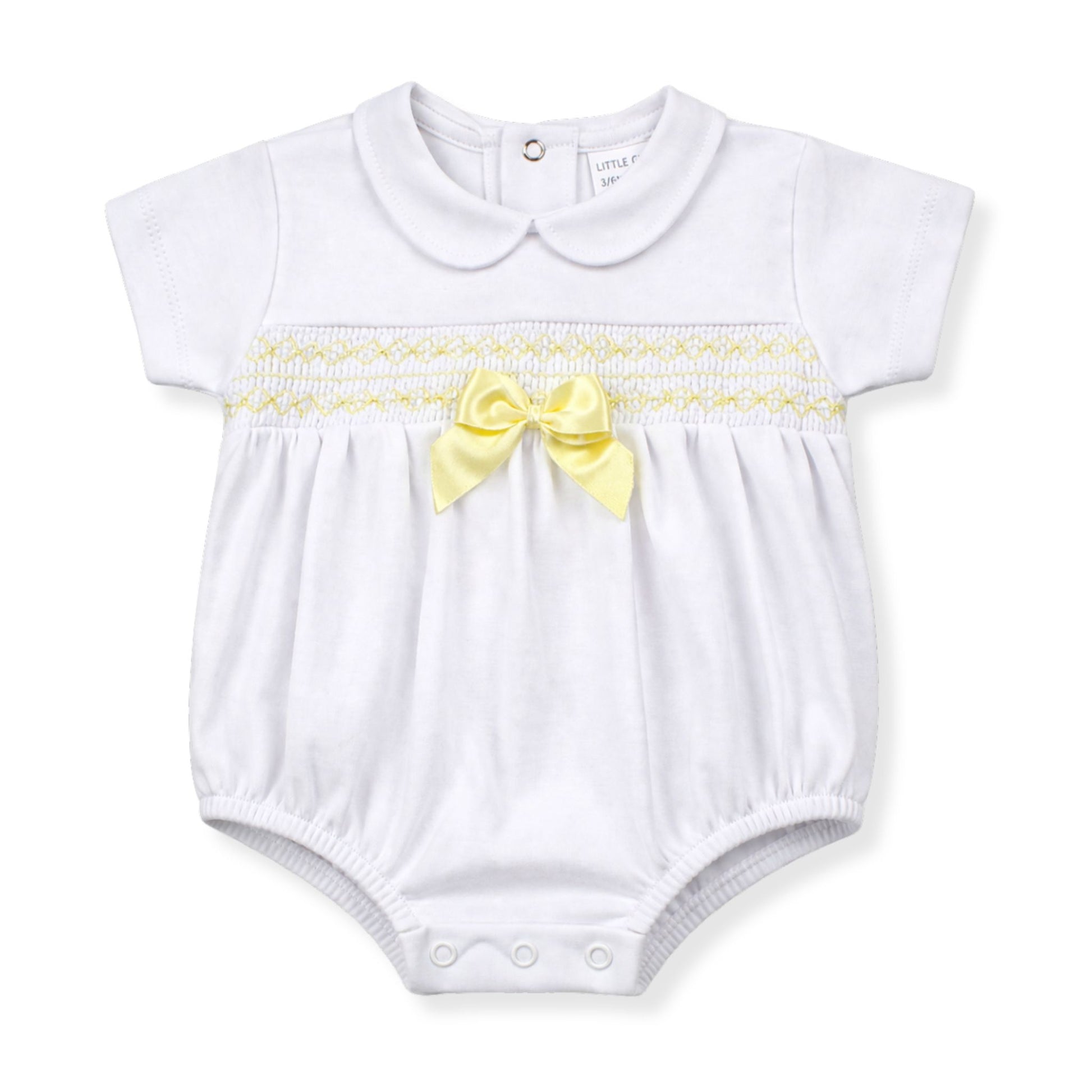 White baby romper with yellow bow and trim on a white background