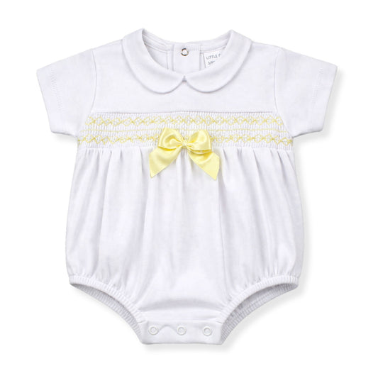 White baby romper with yellow bow and trim on a white background