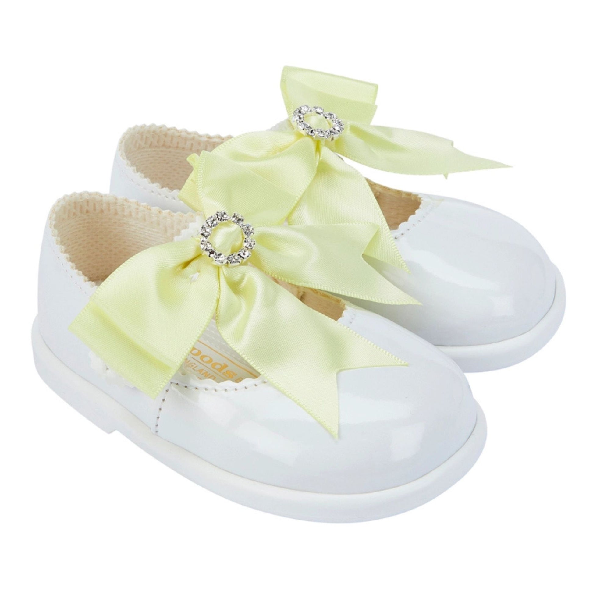 White shoes with yellow bows and rhinestones on a white background