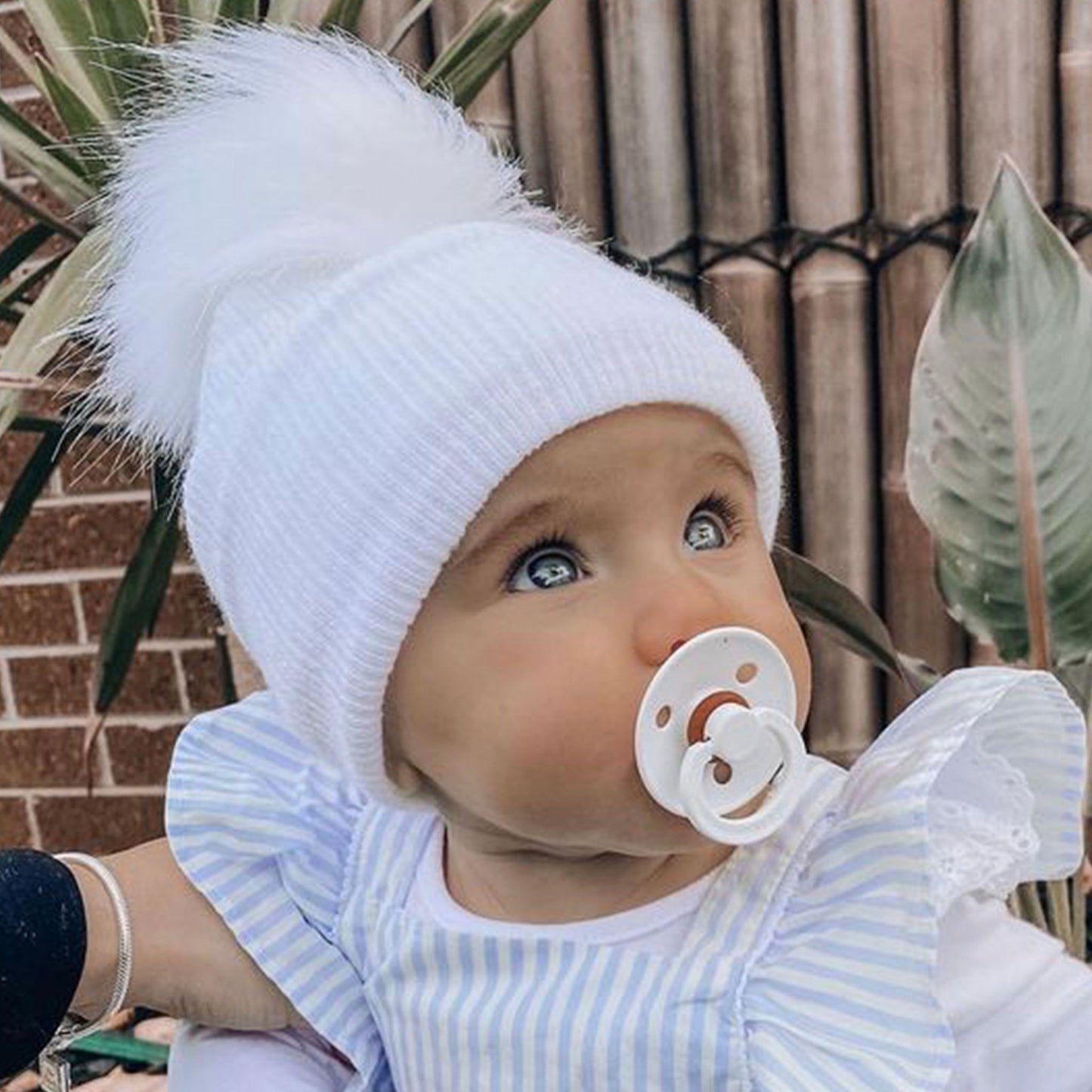 white knitted pom pom hat