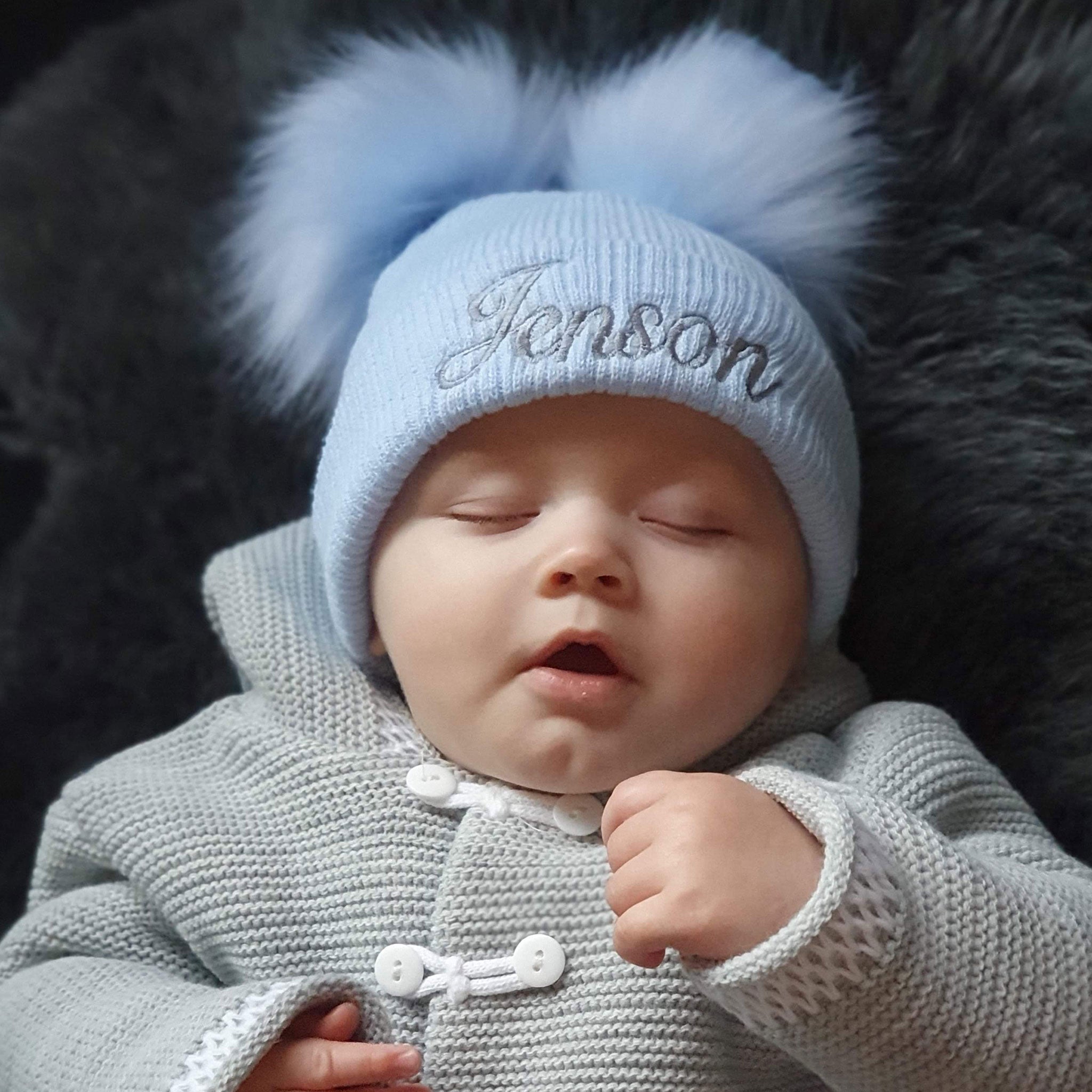 personalised pastel blue baby hat with pom poms
